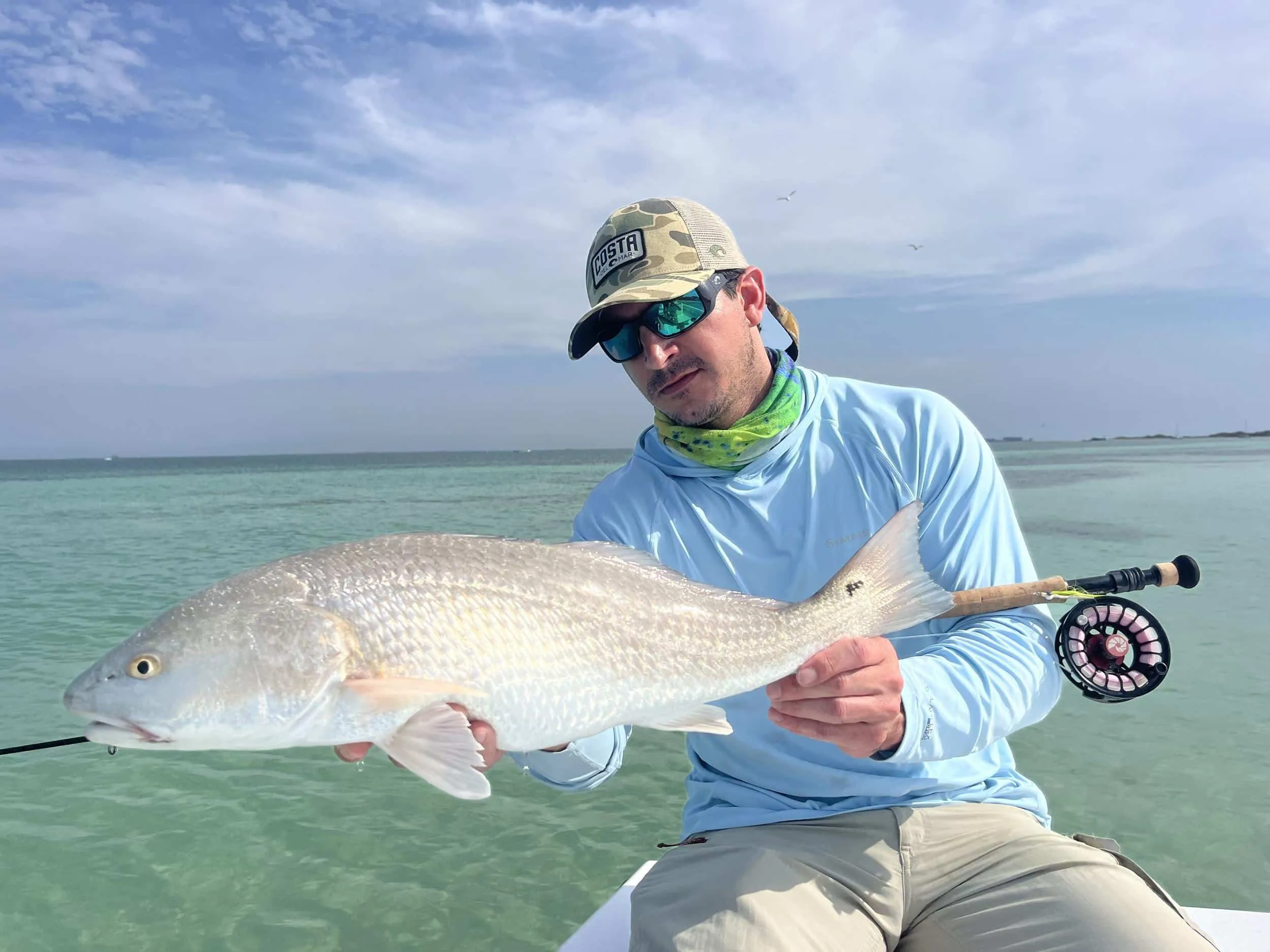 Client with a fly fishing catch aboard Captain David White's charter