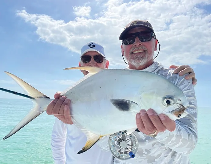 Fisherman on a boat holding a pompano